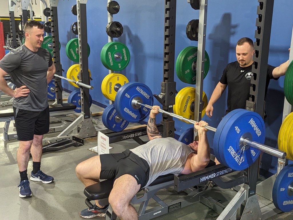 A photo of a strong guy bench pressing a lot of weight. Image by Mike Strasser (public domain)